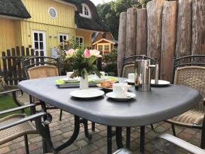 a gray table with flowers on a patio at Ferienhaus Zander mit Sauna in Born