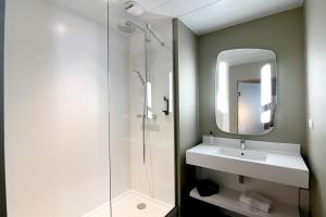 a bathroom with a shower and a sink and a mirror at ibis Nantes Saint Herblain in Saint-Herblain +94 photos