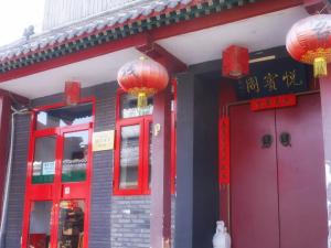un edificio con puertas rojas y linternas rojas en Beijing Yue Bin Ge Courtyard Hotel, en Beijing
