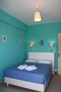 Un dormitorio azul con una cama con toallas. en Porto Panorama, en Porto Heli
