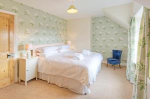 a bedroom with a bed and a blue chair at Thornton Farm Cottages in Berwick-Upon-Tweed