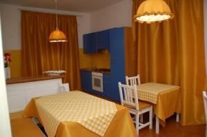cocina con armarios azules, mesa y sillas en B&B Milù, en Civitanova Marche