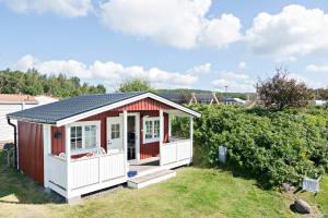 a small red and white shed with a porch at First Camp Kärradal-Varberg in Varberg