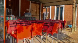 una mesa con sillas naranjas y un mantel rojo y negro en Pidurangala Hostel en Sigiriya