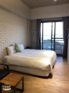 墾丁的住宿－HIDO旅店，一间卧室设有一张大床和一个大窗户