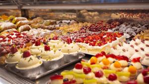 a display case with many different types of cakes and pastries at Duomo Luxury Suite Catania in Catania