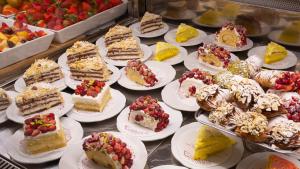 a bunch of cakes and pastries on plates on a table at Duomo Luxury Suite Catania in Catania