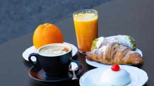 a table with a cup of coffee and a plate of food at Duomo Luxury Suite Catania in Catania