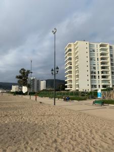 una spiaggia sabbiosa con edifici sullo sfondo e un lampione di Condominio Papudo Laguna, Avenida El Estero 203 a Papudo