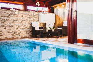 a swimming pool in a room with a brick wall at Barackos Wellness Villa Fót in Fót