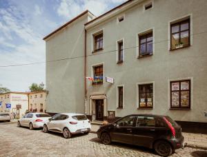 een groep auto's geparkeerd voor een gebouw bij 3 Bros' Hostel Cieszyn in Cieszyn