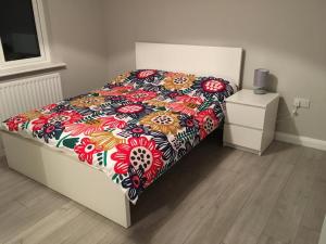 una cama con un edredón colorido en un dormitorio en Byrestown Cottage en Kells