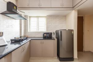 eine Küche mit einem Kühlschrank aus Edelstahl und einem Fenster in der Unterkunft Misty Meridian Serviced Apartments in Bangalore