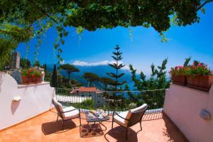 拉維羅的住宿－魯菲洛酒店，庭院设有桌椅,享有美景。