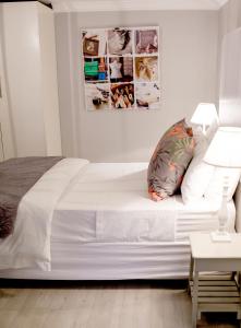 a white bed in a white bedroom with a bedside table at 1926 Self Catering in Piketberg