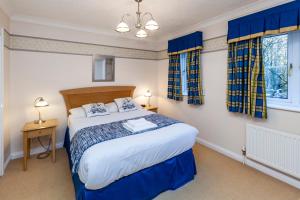 Schlafzimmer mit einem großen Bett und blauen Vorhängen in der Unterkunft Churchill Way Suite in Basingstoke