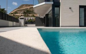 een huis met een zwembad naast een gebouw bij Modern sea front Sunny Beach in Alicante