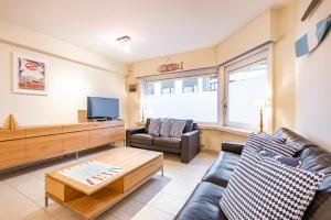 un soggiorno con divano e TV di Centrally located apartment in Knokke a Knokke-Heist