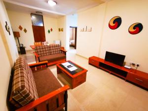 a living room with a couch and a television at Peponi Living Spaces in Kigali