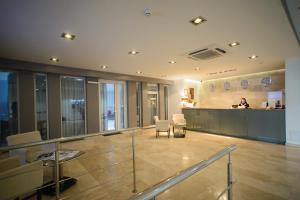 a lobby with a woman sitting at a counter in a building at Optima Collection Kharkiv Hotel in Kharkiv