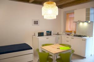 eine Küche mit einem Tisch und Stühlen sowie einem Tisch und einer zusätzlichen Beleuchtung in der Unterkunft CaseOspitali - CASA CARAMELLI bilocale in corte storica in Cernusco sul Naviglio