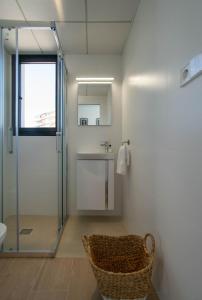 a bathroom with a shower and a sink and a basket at Modern sea front Reef in Alicante