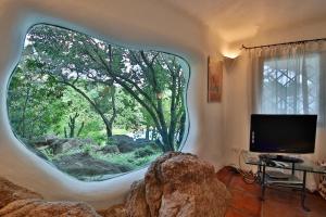 un soggiorno con una grande finestra circolare in una casa di Villa Abbaiola By KlabHouse a Porto Cervo