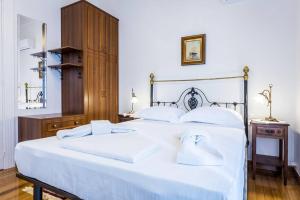 ein Schlafzimmer mit einem großen weißen Bett mit weißen Kissen in der Unterkunft Neoclassical apartment with 3 bedrooms in Piraeus in Piräus