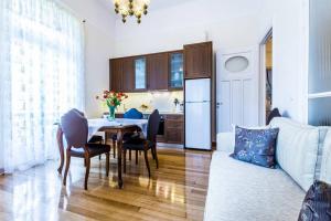 eine Küche und ein Wohnzimmer mit einem Tisch und einem Sofa in der Unterkunft Neoclassical apartment with 3 bedrooms in Piraeus in Piräus