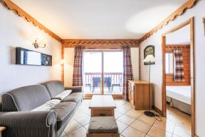 a living room with a couch and a bed at Residence l'Ecrin des Neiges - maeva Home in Tignes