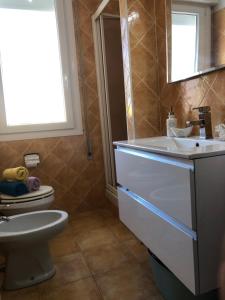 a bathroom with a white sink and a toilet at Ca' Adriana in Lido di Jesolo +17 photos
