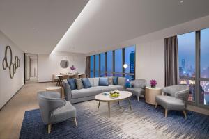 a living room with a couch and chairs and a table at Ascott Raffles City Chongqing in Chongqing
