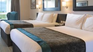 
a hotel room with two beds and two nightstands at Innisfallen Hotel in Killarney
