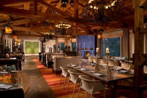 Rancho Valencia Resort and Spa في رانشو سانتا في: غرفة طعام مع طاولة وكراسي طويلة