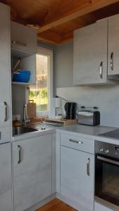 a white kitchen with white cabinets and a window at Traumhafte Ferienwohnung mit Pool in Steinen