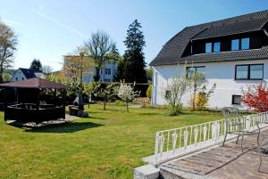 オストゼーバート・ゼリンにあるNEU _ Ferienhaus Meeresgefluesterの白屋敷・塀のある庭