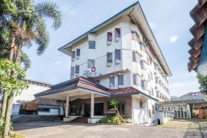 un gran edificio blanco con planta Aveth en SUPER OYO Collection O 25 Hotel Baltika, en Bandung