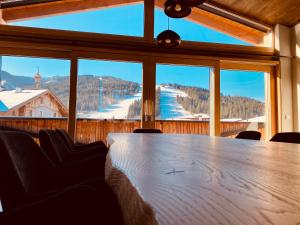 a table in a room with a view of a mountain at AlpinLodge Flachau in Flachau