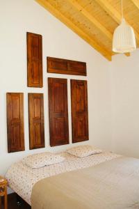 una camera da letto con un letto con porte in legno e un soffitto di Casa do Sobreiro-Quinta do Briando a Portalegre