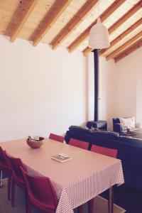 a dining room with a table and red chairs at Casa do Sobreiro-Quinta do Briando in Portalegre