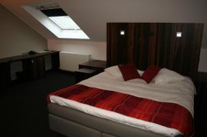um quarto com uma cama e uma clarabóia em Hotel Carpinus em Lovaina