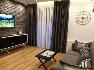 a living room with a couch and a flat screen tv at Luxury Spa Suite in Belgrade