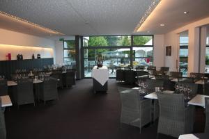 uma sala de jantar com mesas, cadeiras e janelas em Hotel Carpinus em Lovaina