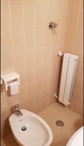 een badkamer met een wit toilet en een wastafel bij trilocale sulle piste da sci in Abetone