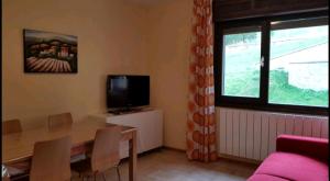 a living room with a dining table and a television at trilocale sulle piste da sci in Abetone