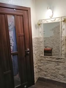 Łazienka z lustrem i drewnianymi drzwiami w obiekcie У Ксені w mieście Morszyn