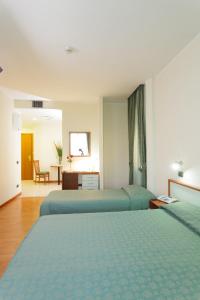 Cette chambre comprend deux lits et un bureau. dans l'établissement Astor Hotel Vintage, à Frosinone