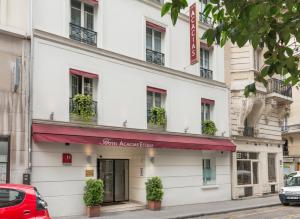 a white building with a red awning at Acacias Etoile in Paris