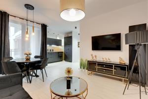 - un salon avec un canapé et une table dans l'établissement NORDBYHUS Apartamenty Garden Gates, à Gdańsk