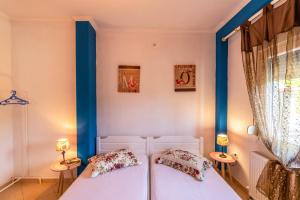 two beds in a room with blue trim at Demmy's Apartment in Potamiá